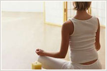 Woman dressed in white doing some yoga on the floor