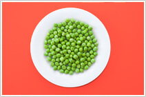 A big white plate full of peas