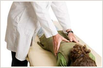 A woman layed down is being given a massage for her back pain