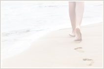 Woman walks on the sand and leaves her footprints